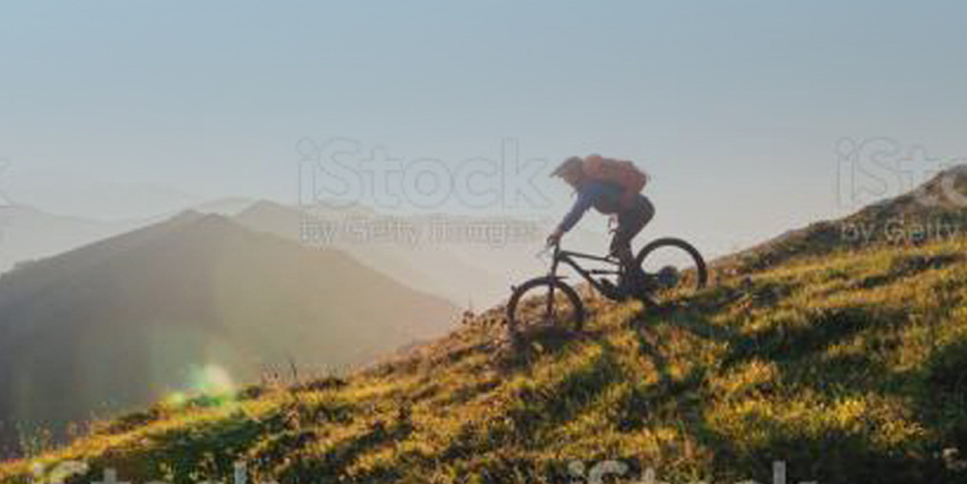 Mountain biker riding downhill in the mountains.