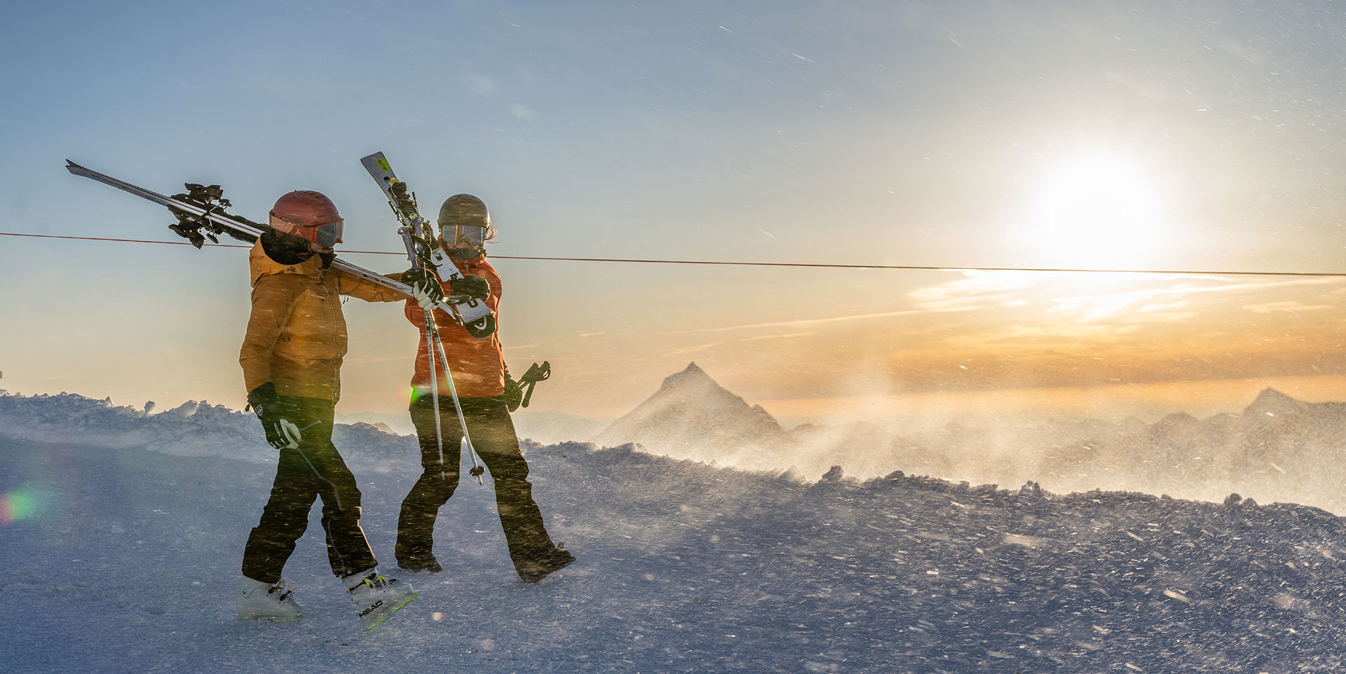 Saas Fee i Sveits. To glade skikjørere i solnedgang på en skireise til Alpene.